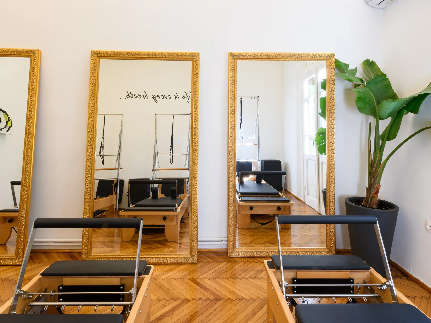 Αίθουσα Reformer Pilates με χρυσούς καθρέφτες